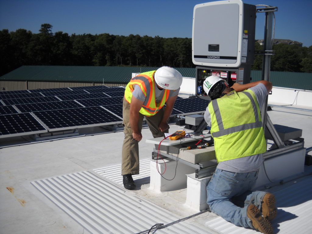 Beaumont Solar electricians making wiring connections at one of the system inverters.