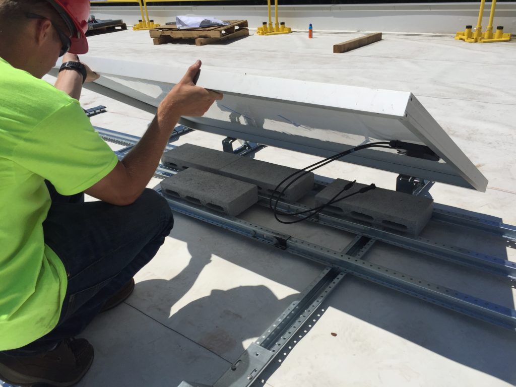 The Beaumont Solar project foreman inspects the workmanship of the first panel installed to ensure all the ballast blocks are installed in the correct position and in the correct volume as designed by our solar engineering team.
